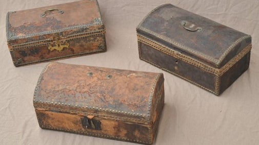 Three 18th century wood and leather travelling trunks, pictured after receiving conservation.